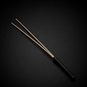 Badine BDSM double brin en rotin naturel avec manche en similicuir, un accessoire de discipline élégant et précis.